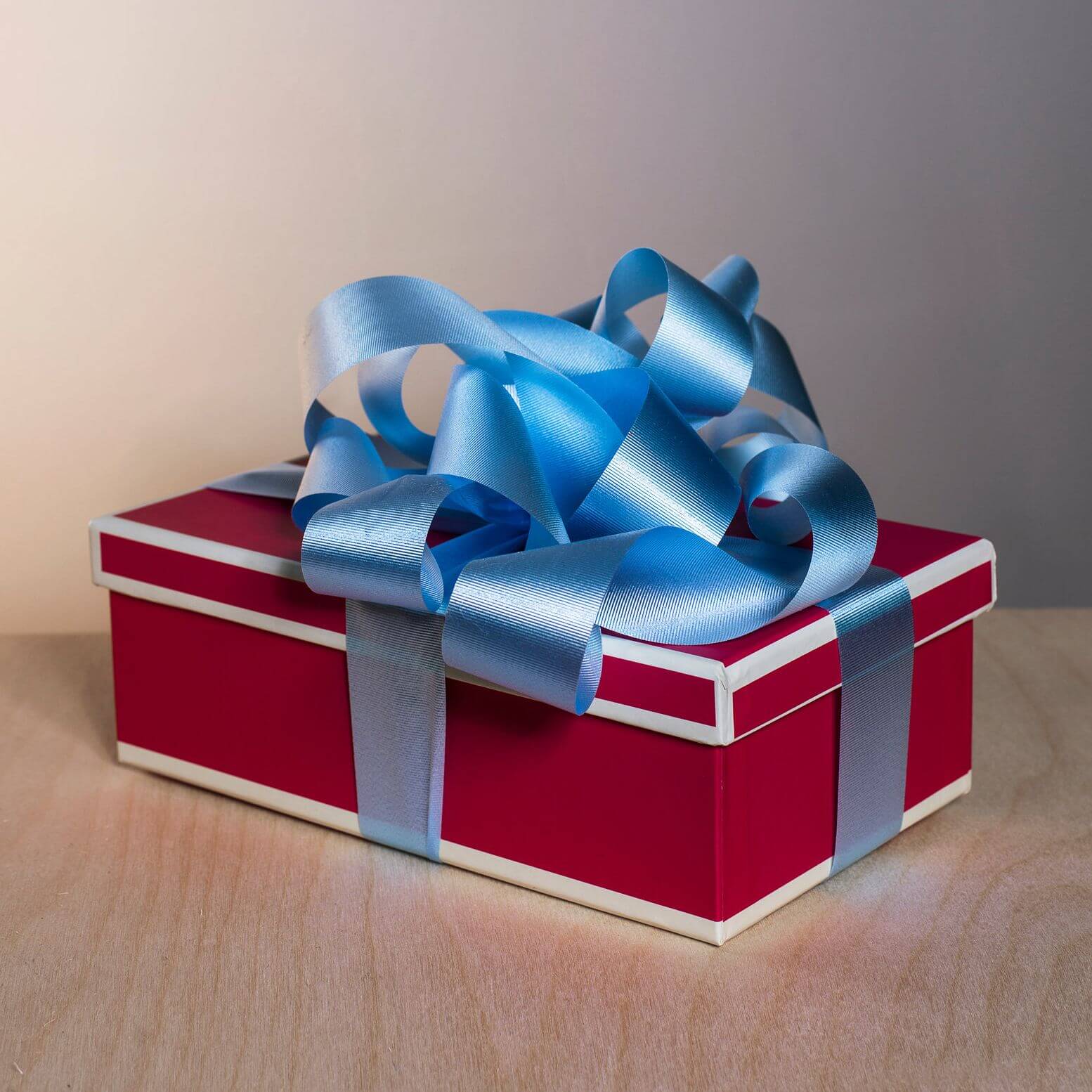 A Christmas present in a red box with blue ribbon.