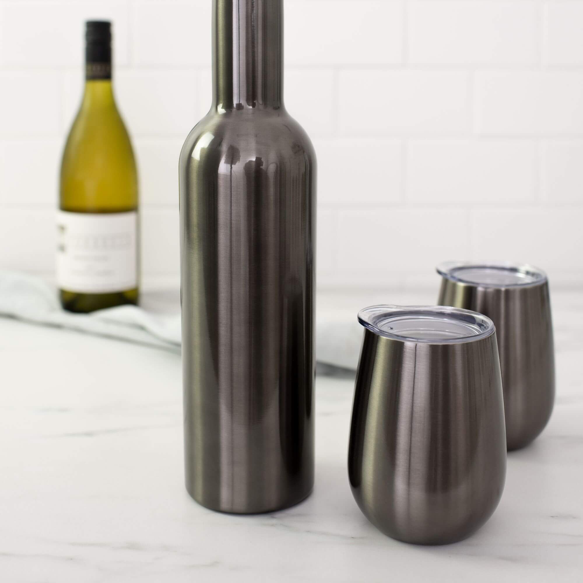 Two insulated wine glasses and an insulated wine bottle on a kitchen bench