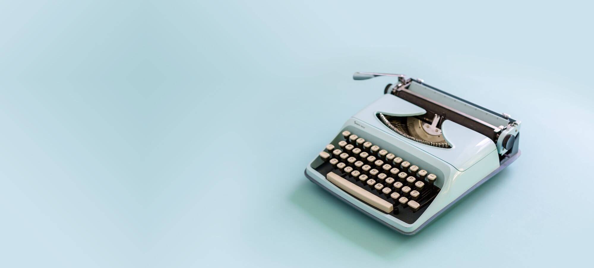 A blue typewriter against a blue background