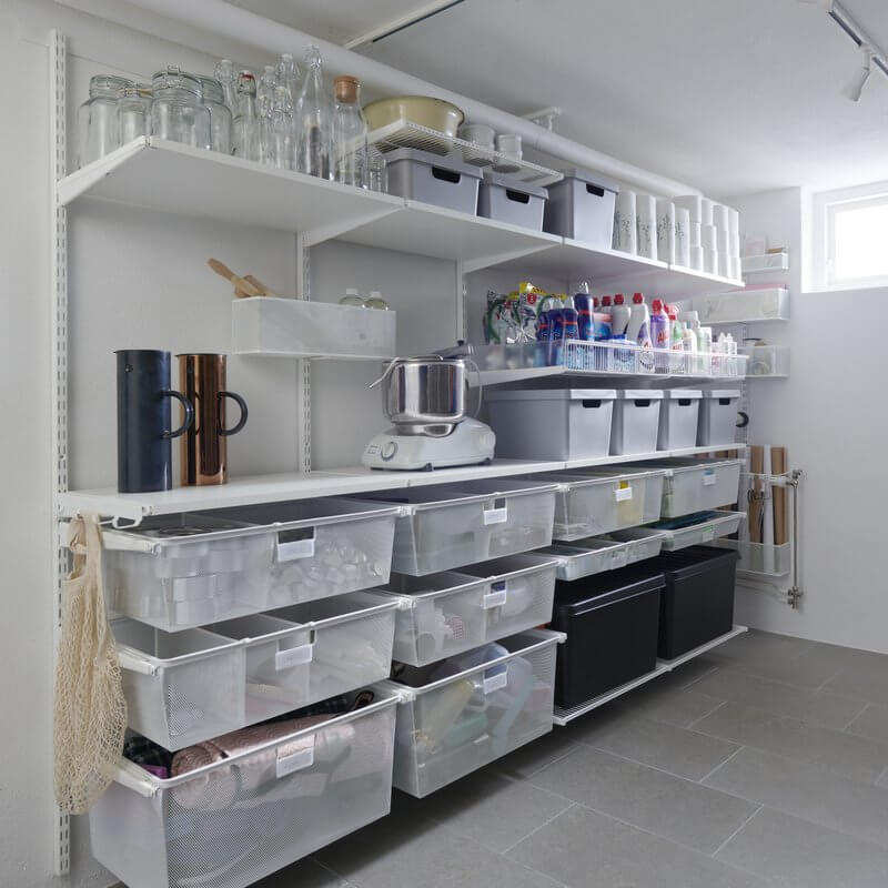 A laundry room with White Elfa shelving and Gliding Mesh Drawers
