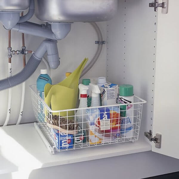 An Elfa Easy Glider with a Wire Basket storing cleaning supplies in a laundry cupboard