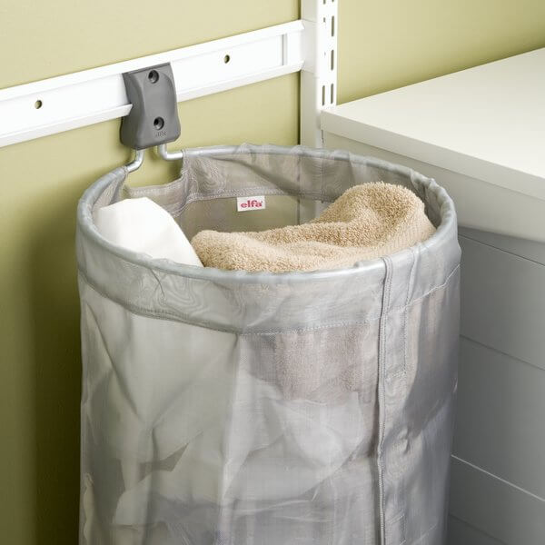 A grey Elfa Mesh Storage Bag used as a wall-mounted laundry hamper