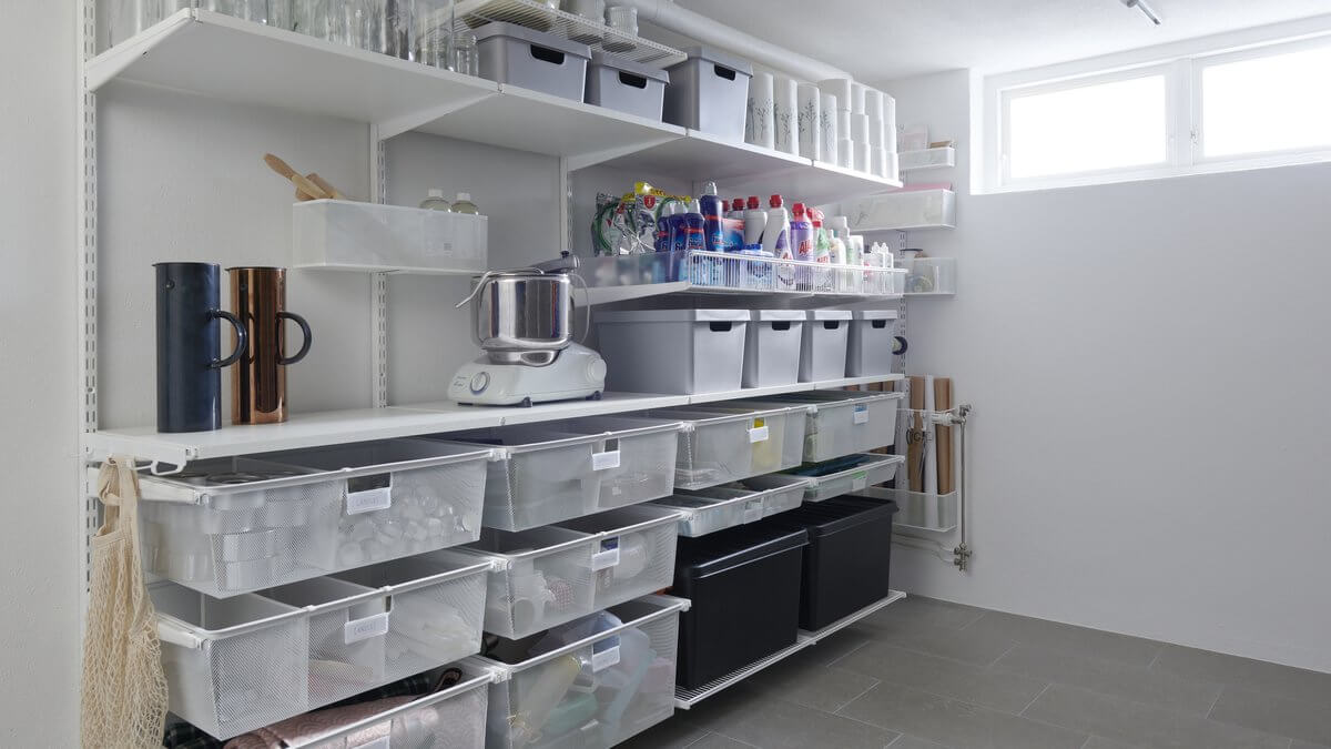 A laundry room with White Elfa shelving and Gliding Mesh Drawers