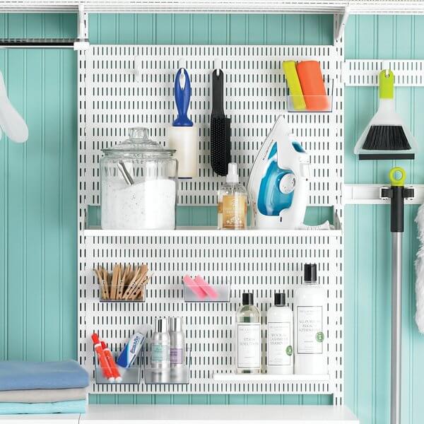 Two White Elfa Storing Boards and a Reversible Metal Shelf Tray storing ironing and cleaning accessories in a laundry room
