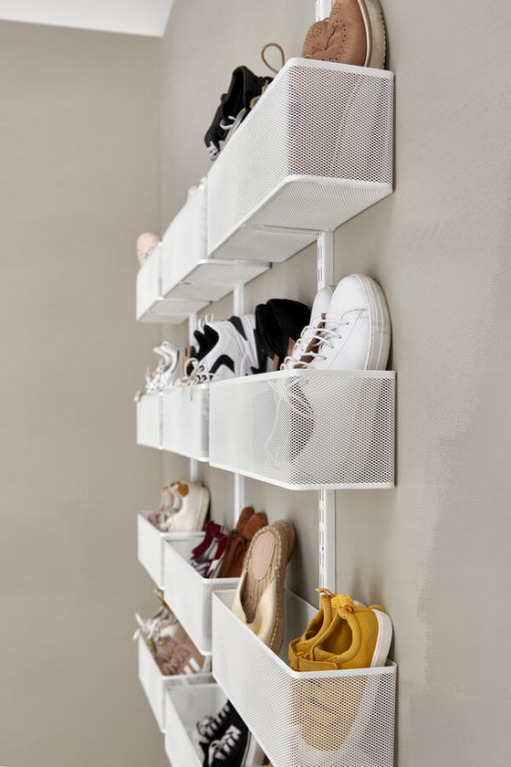 A White Elfa Utility Wall & Door system with Mesh Utility Baskets, used as a wall-mounted shoe rack