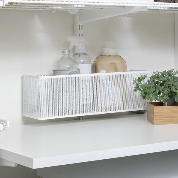 An Elfa Large Mesh Utility Basket installed on a White Hang Standard above a melamine bench