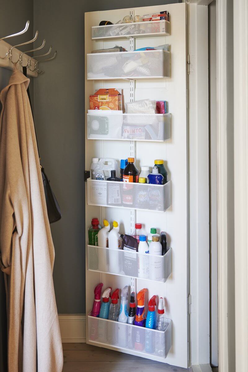 A White Elfa Utility Wall & Door system with Mesh Utility Baskets, used for over-the-door storage of bottles in a pantry or laundry