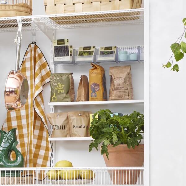 Two White Elfa Reversible Shelf Trays storing food bags in a pantry