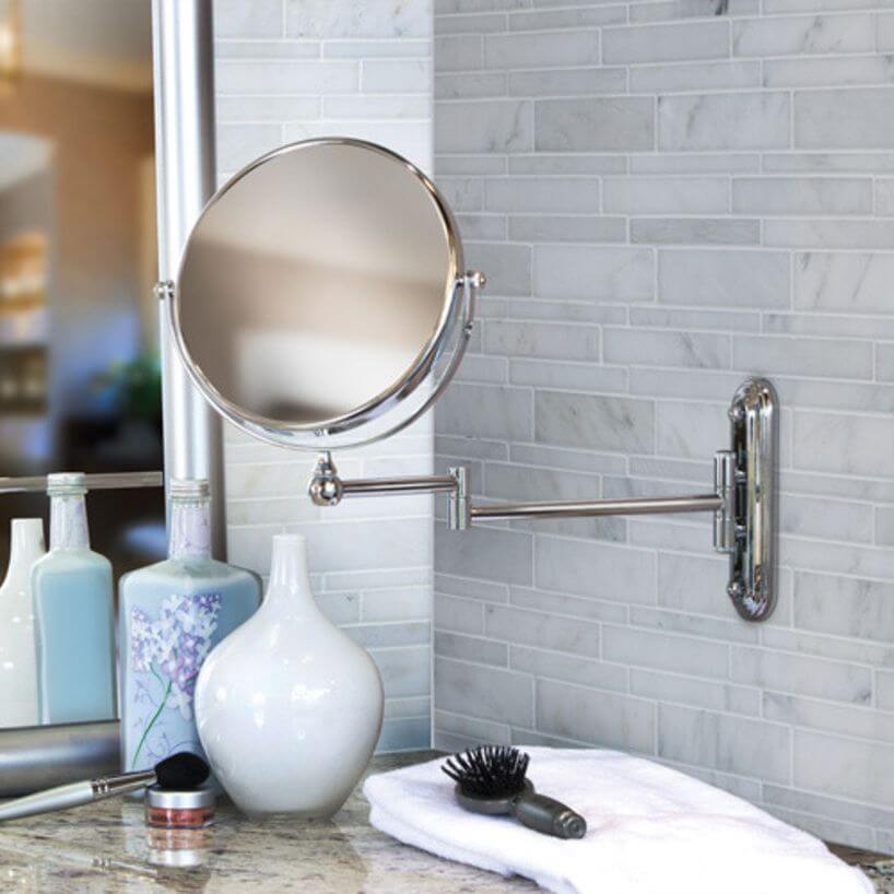 A wall mounted makeup mirror above a bathroom vanity