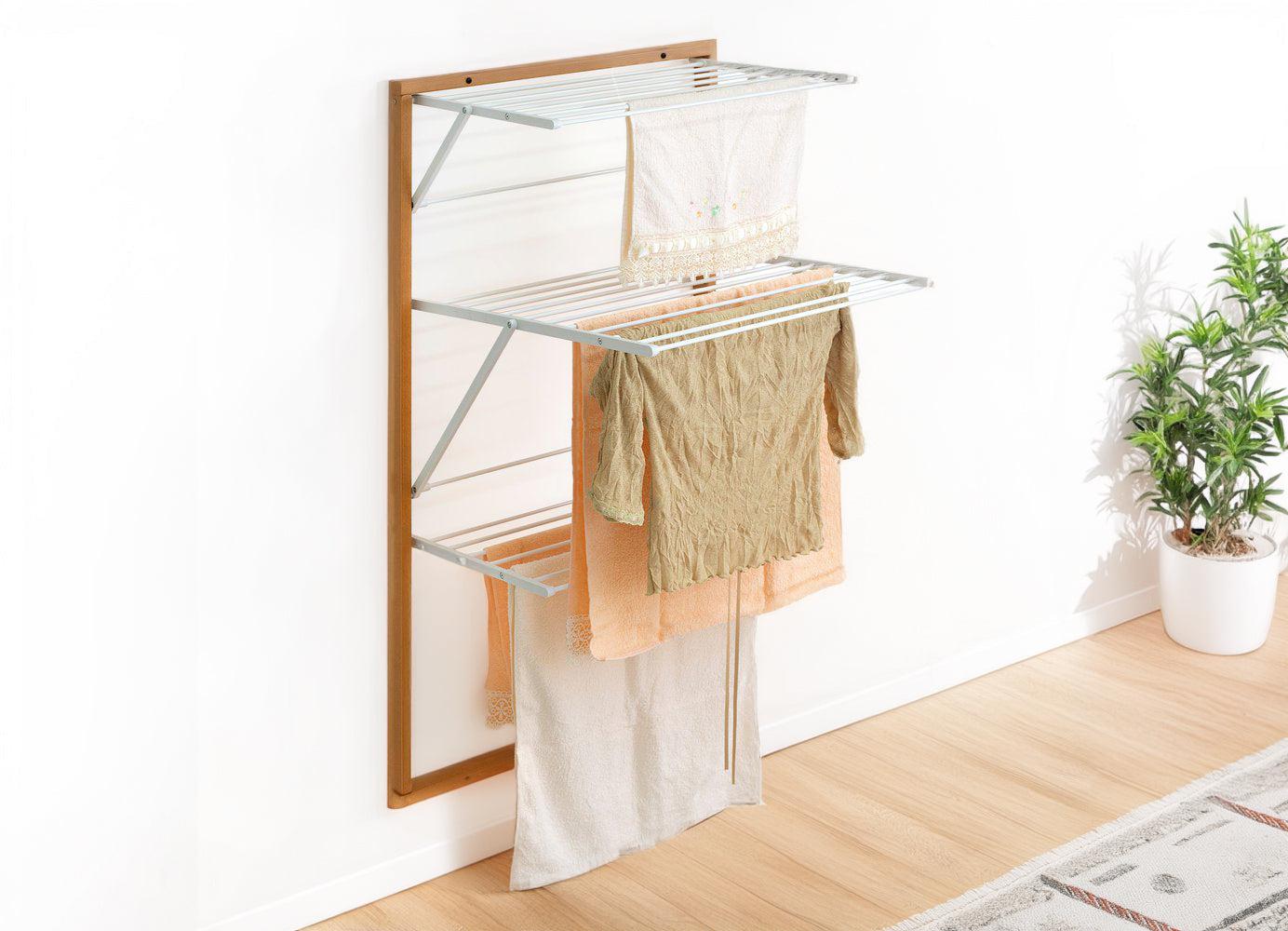 A rust proof aluminium clothes airer on a grey tiled wall