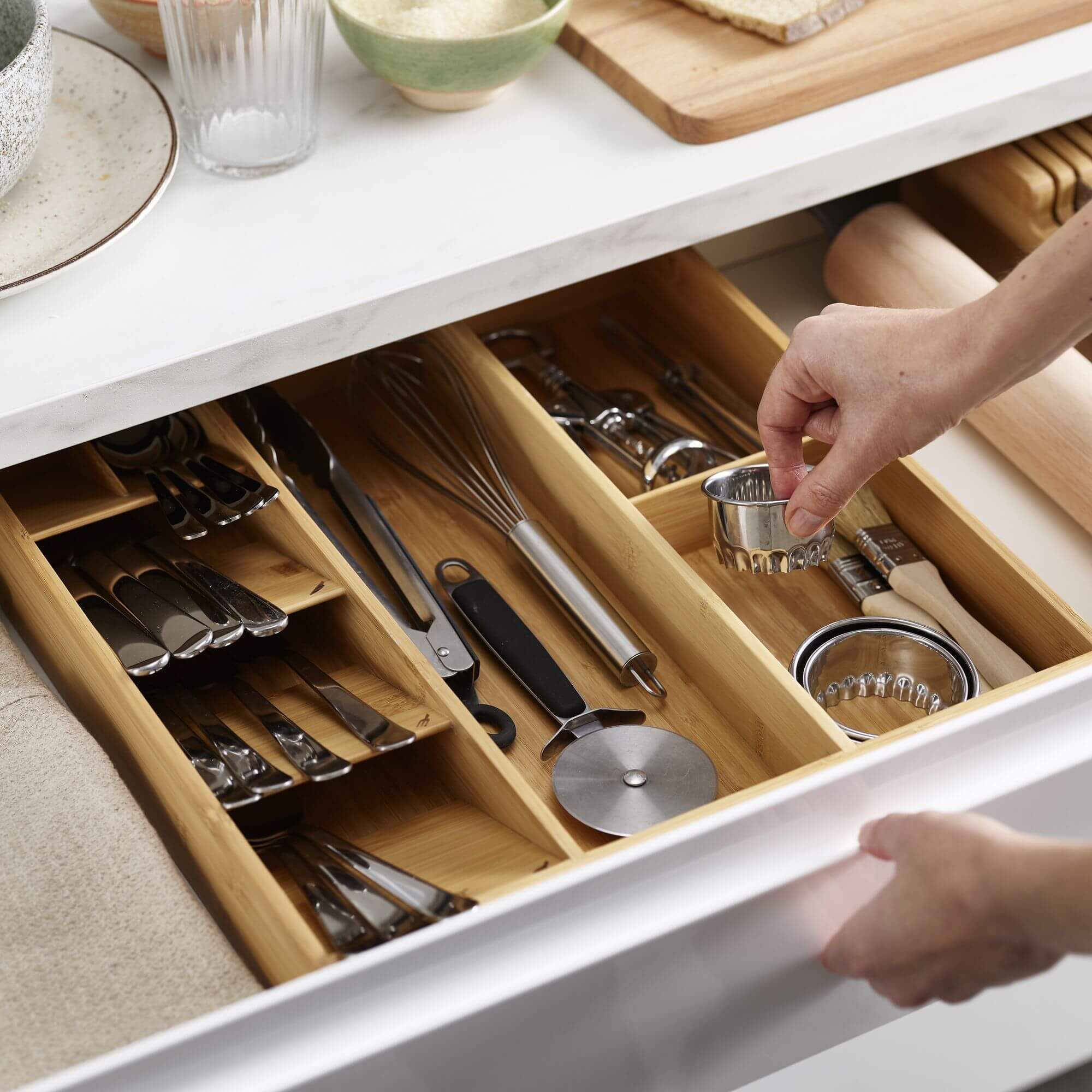 A bamboo kitchen cutlery tray inside a drawer