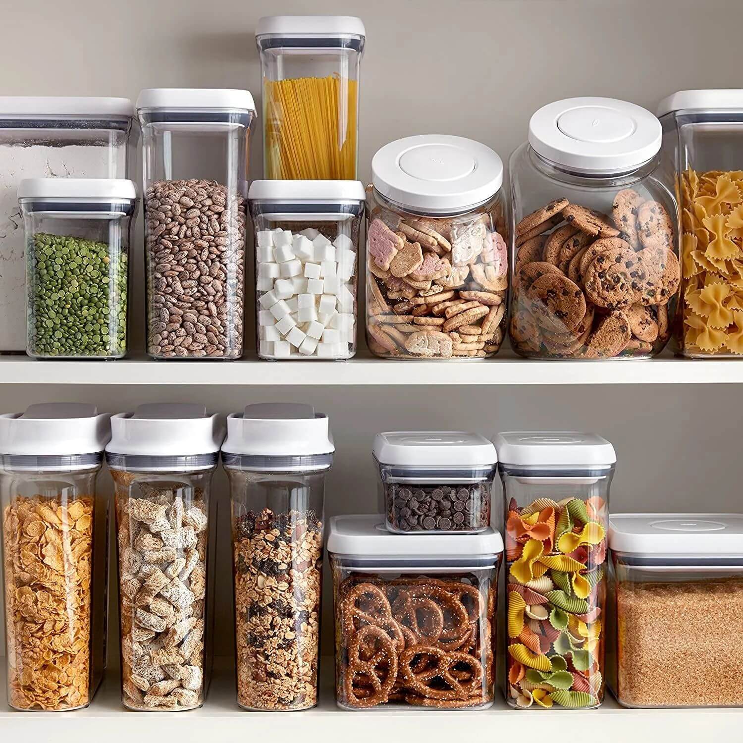 OXO kitchen containers on a pantry shelf with pasta, cookies and other pantry items stored inside