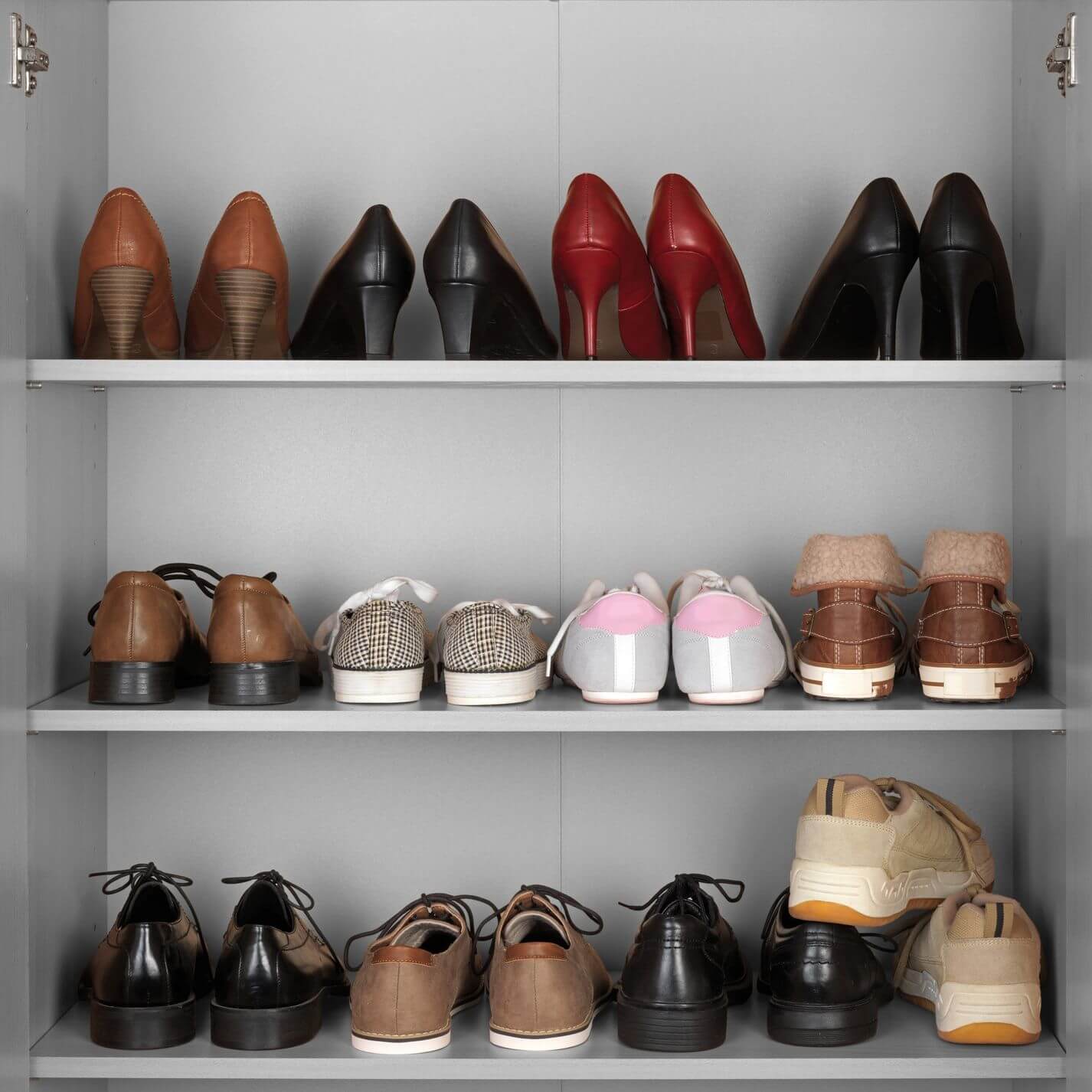 Pairs of shoes stored on white cupboard shelves