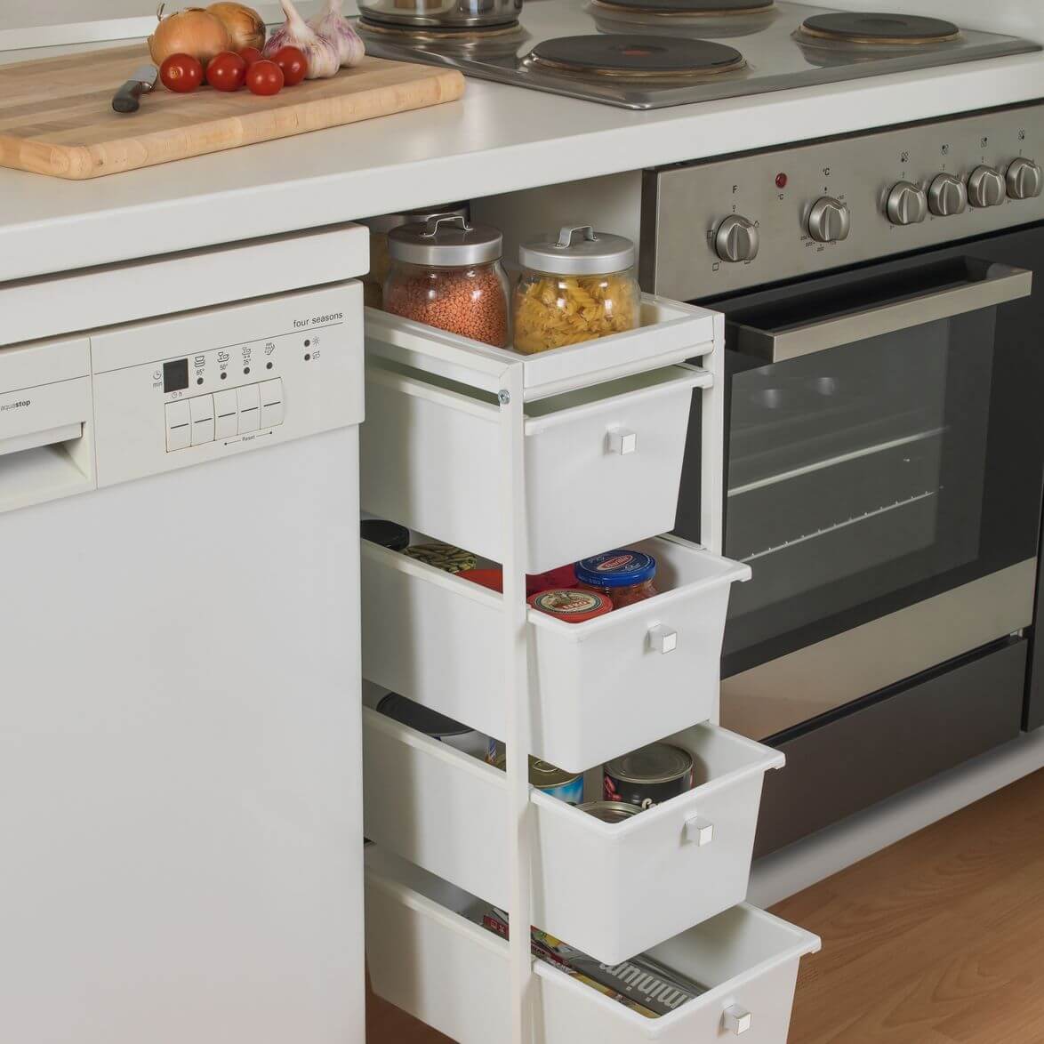 A slim white storage trolley with four drawers next to a dishwasher in the kitchen