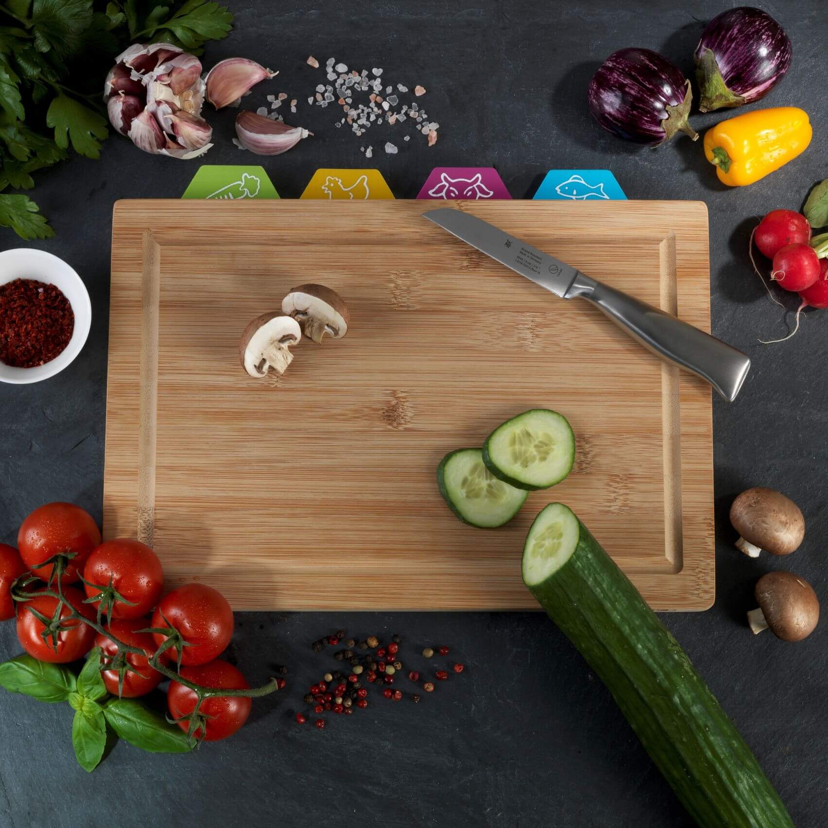 Cucumber and mushrooms being cut on a Belle Bamboo Chopping Board Set