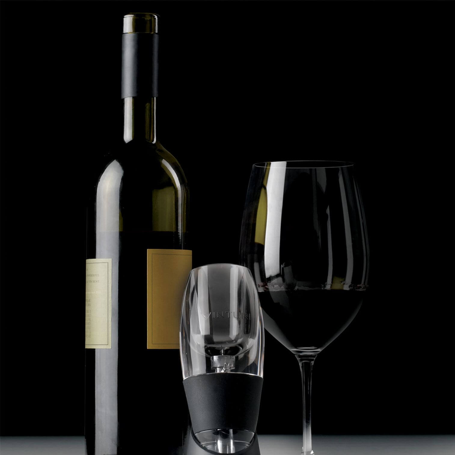 A wine bottle and glass next to a wine aerator