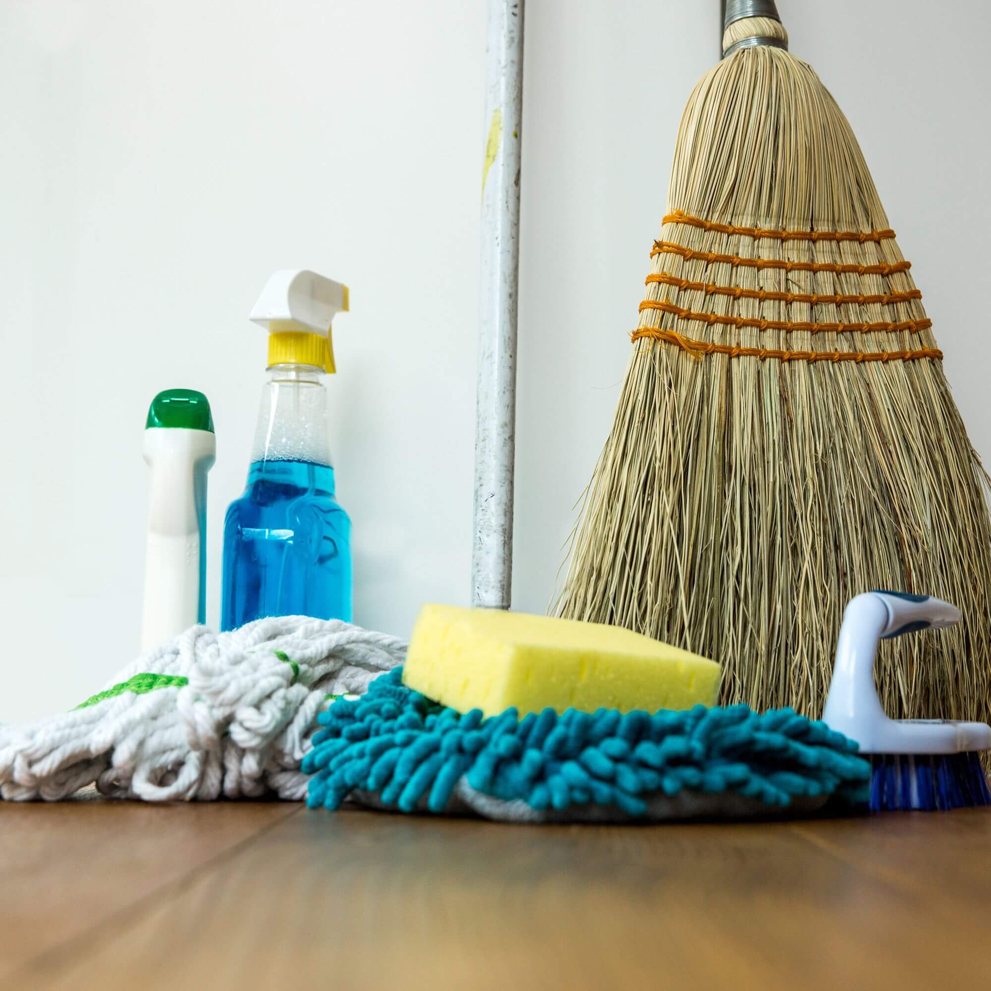 A broom and bottles of cleaning supplies