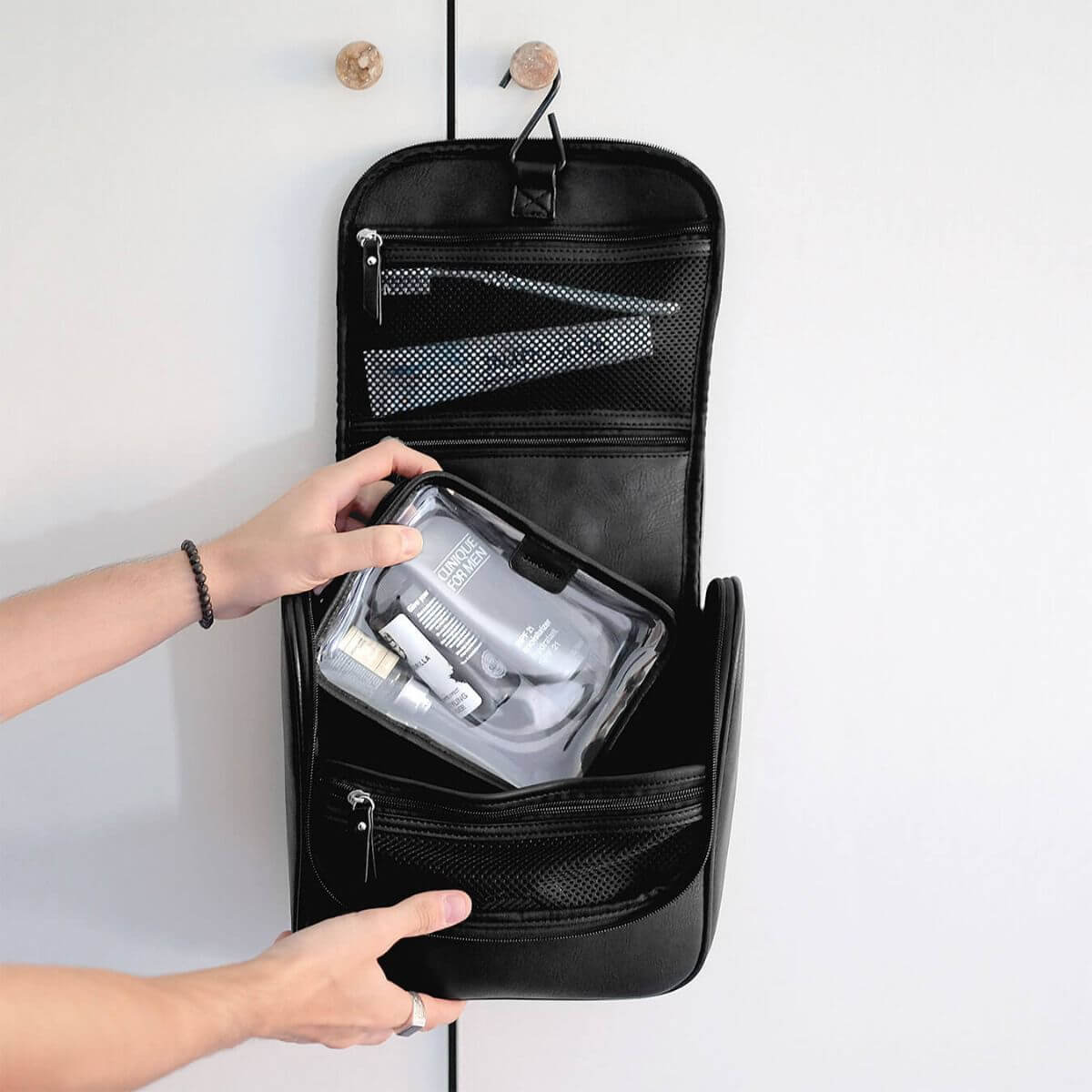 Black leather travel toiletry bag with travel items inside