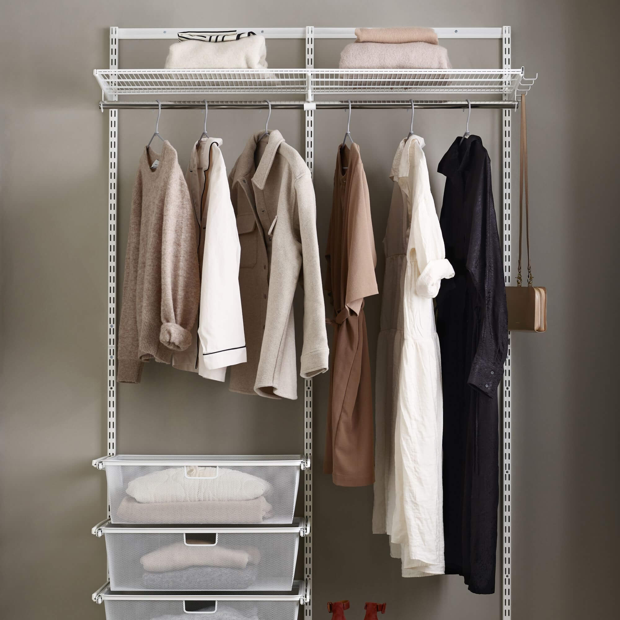 An Elfa wardrobe system with clothes hanging rail, wardrobe shelves and accessory storage