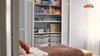 A bedroom featuring white Elfa wardrobe shelving and storage solutions