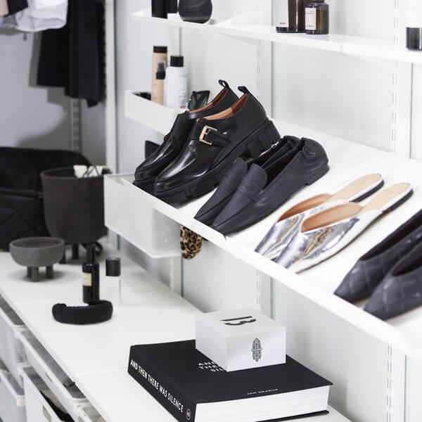 White Elfa Angled Metal Shelves installed in a wardrobe holding dress shoes