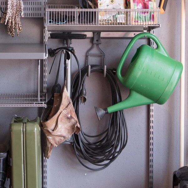 Extension cords, watering cans and tools stored on a Platinum Elfa Storage Track