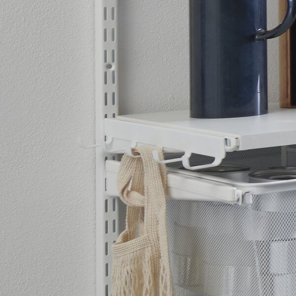 A cotton bag hanging on a White Elfa Bracket Hook