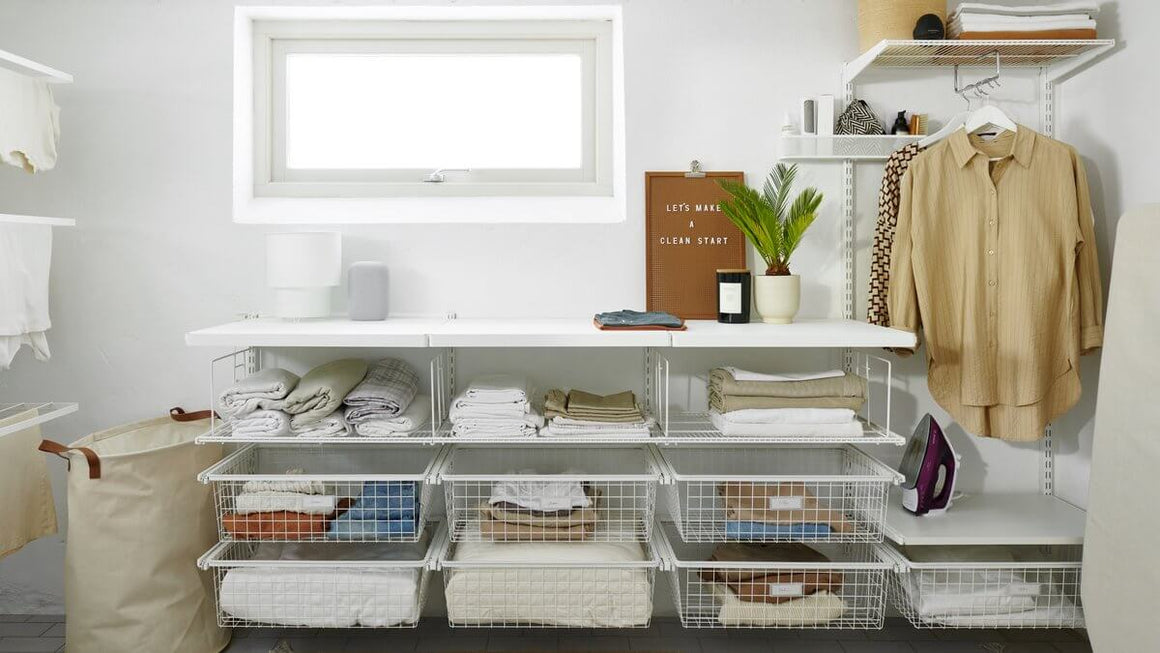 A White Elfa laundry storage system with Click In Work Surfaces, Wire Shelves and Gliding Wire Drawers
