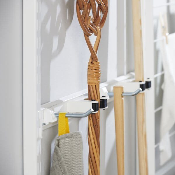 Brooms, mops and cleaning items organised on a White Elfa Storage Track in a laundry
