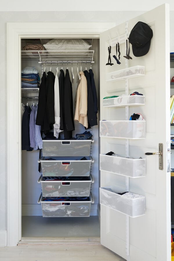A White Elfa Utility Wall & Door system with Mesh Utility Baskets and a Centre Storing Board, used for over-the-door storage of hats, ties and other clothing items