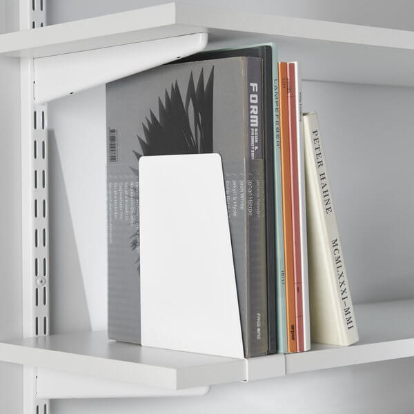 Books stored upright on a melamine bookshelf with Elfa Clip On Book Ends