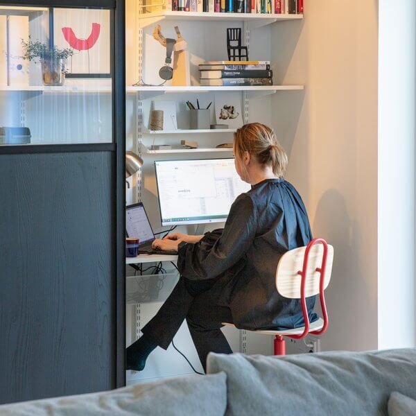 A woman sits at an Elfa home office desk