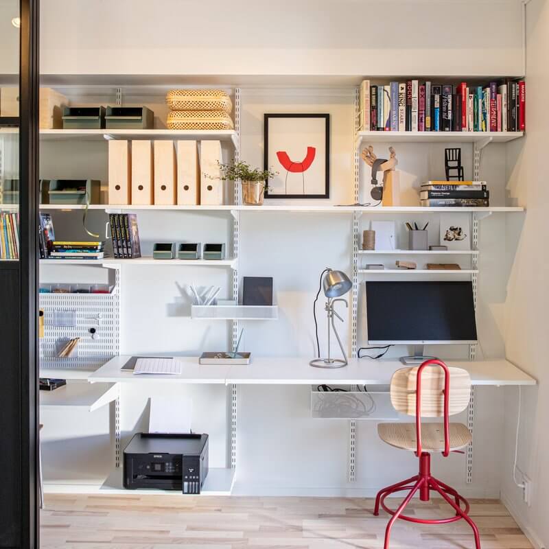 A home office with White Elfa melamine shelving installed
