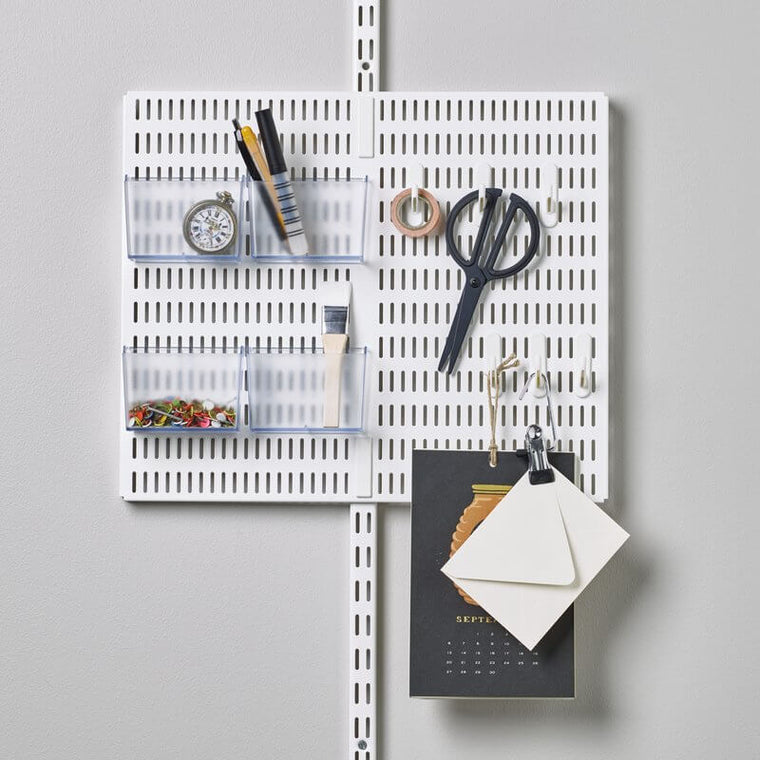 A White Elfa Centre Storing Board with hanging hooks and containers for organising office items