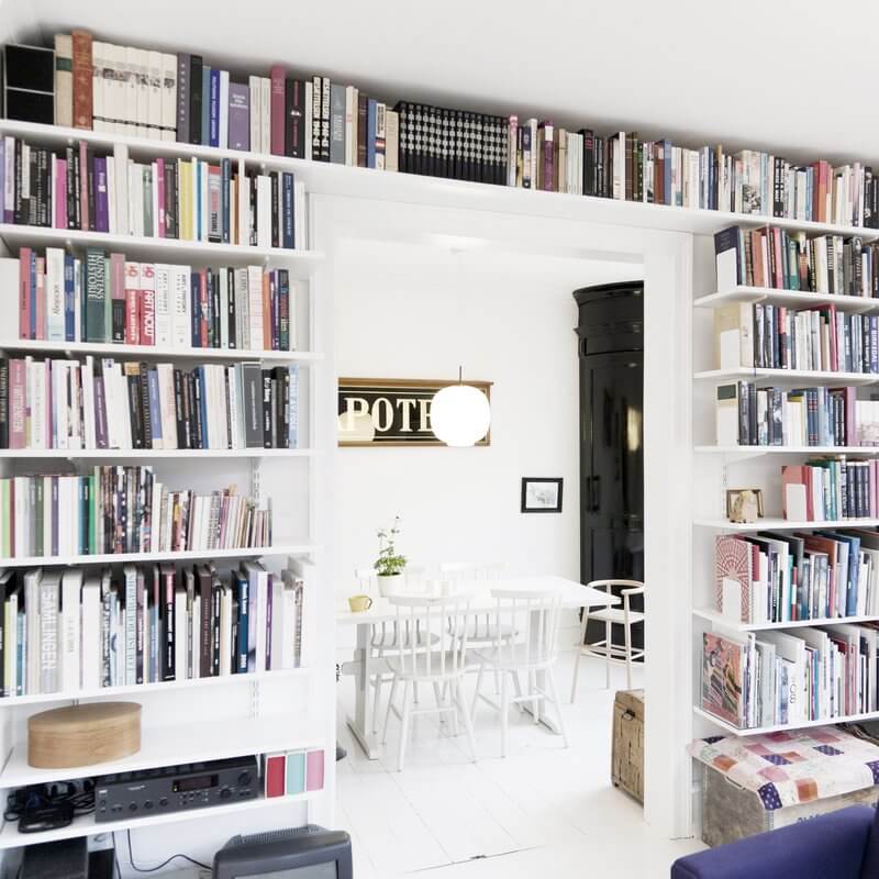 White Elfa melamine shelves installed as a bookshelf in a living room