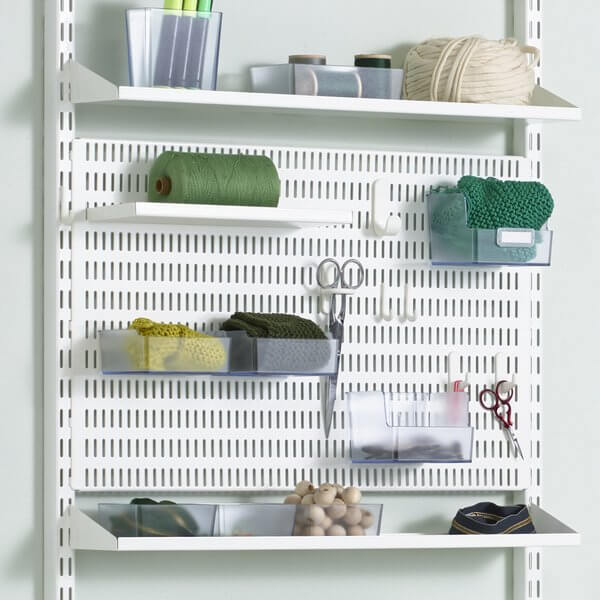 A White Elfa Storing Board organising thread, scissors and fabric in an office
