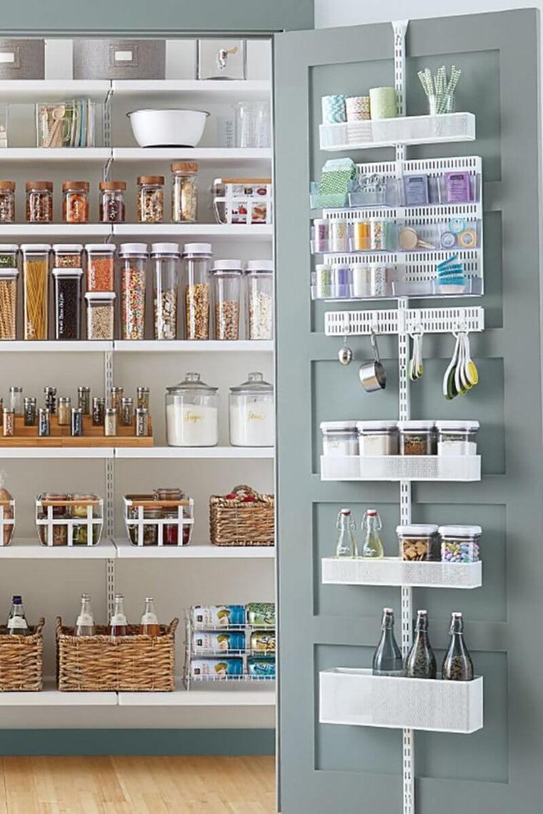 A White Elfa Utility Wall & Door system with Mesh Utility Baskets and a Centre Storing Board, used for over-the-door pantry storage in the kitchen