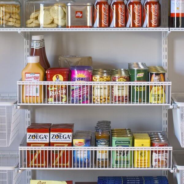 Two White Elfa Wire Shelf Baskets installed in a pantry to store food containers and jars