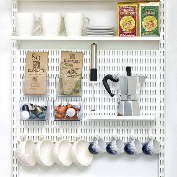 A White Elfa Storing Board installed in a kitchen, organising cups, mugs, plates and coffee
